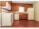 Kitchen featuring wood cabinets, white appliances, and hardwood floors at 5243 Valleyview Dr, Acworth, GA 30102