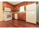 Kitchen featuring wood cabinets, white appliances, and hardwood floors at 5243 Valleyview Dr, Acworth, GA 30102