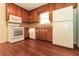 Cozy kitchen equipped with white appliances, wood cabinets, and hardwood floors offers a functional cooking space at 5243 Valleyview Dr, Acworth, GA 30102