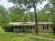 Charming single-story home featuring a covered front porch and surrounded by lush greenery and mature trees at 710 Seals Rd, Dallas, GA 30157