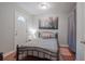 Comfortable bedroom with wood floors, side table, and door leading to a hallway at 2650 Montego Dr, Buford, GA 30519