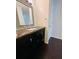 Bathroom vanity with dark cabinets, marble countertop, framed mirror and white door at 3432 Ivys Walk, Atlanta, GA 30340