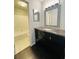 Bathroom featuring a vanity with dark wood cabinets, marble countertop, and decorative mirror, with tub/shower combo at 3432 Ivys Walk, Atlanta, GA 30340