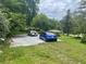 A spacious driveway with parking for two cars surrounded by a lush green lawn and mature trees at 3629 Centerview Dr, Marietta, GA 30066
