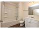 Bright bathroom with a tub/shower combo, stylish vanity, and dark wood-look flooring at 4255 Sunflower Cir, Cumming, GA 30040