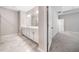 Modern bathroom with a double vanity, neutral paint, tile floors, and an open door to a carpeted bedroom at 495 Duval Dr, Alpharetta, GA 30009