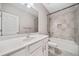 Bathroom featuring a tiled shower-tub combination, a large mirror, and a sink with white countertops at 495 Duval Dr, Alpharetta, GA 30009