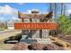 Stone Artisan community entrance sign with landscaped surroundings and a glimpse of the neighborhood at 495 Duval Dr, Alpharetta, GA 30009