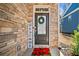 Welcoming front door with stone accents, wreath, and cheerful welcome sign at 495 Duval Dr, Alpharetta, GA 30009