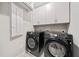 Modern laundry room featuring front-load washer and dryer and storage cabinets at 495 Duval Dr, Alpharetta, GA 30009