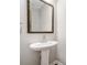 Pedestal sink and large mirror enhance this half bathroom at 495 Duval Dr, Alpharetta, GA 30009
