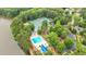 Aerial view of community amenities, including a pool, tennis courts, and clubhouse surrounded by lush landscaping and a lake at 283 Heron Lake Ct, Lawrenceville, GA 30043