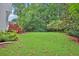 Lush backyard with green grass and tree line. Includes a wooden fence and access to stairs to a raised deck at 283 Heron Lake Ct, Lawrenceville, GA 30043