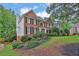 Brick two-story home on a landscaped hill with white trim and black shutters at 283 Heron Lake Ct, Lawrenceville, GA 30043