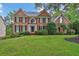 Traditional two-story brick home with a lush green lawn and manicured landscaping at 283 Heron Lake Ct, Lawrenceville, GA 30043