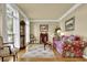 Cozy living room with hardwood floors, floral sofa, and large window with sheer curtains at 283 Heron Lake Ct, Lawrenceville, GA 30043