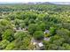 Aerial view of a lush green neighborhood with tree-lined streets and a cityscape in the distance at 4411 Paces Battle Nw, Atlanta, GA 30327