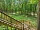 Wooden staircase leading to a sprawling backyard surrounded by lush greenery and mature trees at 4411 Paces Battle Nw, Atlanta, GA 30327