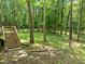 Private backyard with wooden deck, steps, and a fire pit area surrounded by lush trees at 4411 Paces Battle Nw, Atlanta, GA 30327