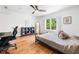 Bright bedroom with hardwood floors, a ceiling fan, a large window, and a comfortable bed with decorative accents at 4411 Paces Battle Nw, Atlanta, GA 30327