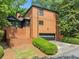Brick two-story home with black garage door and well-maintained landscaping, surrounded by mature trees at 4411 Paces Battle Nw, Atlanta, GA 30327