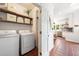 Convenient laundry room with modern washer and dryer, shelving for storage, and tile flooring near kitchen at 4411 Paces Battle Nw, Atlanta, GA 30327