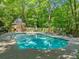 Outdoor pool featuring a bath house, sun loungers, and a serene setting among lush greenery at 4411 Paces Battle Nw, Atlanta, GA 30327