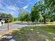 View of the front yard with well-manicured lawn and beautiful, mature trees with long driveway at 505 Sandhill Hickory Level Rd, Carrollton, GA 30116