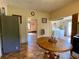 Cozy kitchen with appliances, round table, and tile flooring with a view to another room with a washer and dryer at 505 Sandhill Hickory Level Rd, Carrollton, GA 30116