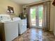 Practical laundry area featuring washer, dryer, water heater, and access to the outdoors through glass doors at 505 Sandhill Hickory Level Rd, Carrollton, GA 30116