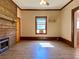 Living room featuring fireplace with wood accent wall, neutral paint, and laminate flooring under ceiling fan lighting at 505 Sandhill Hickory Level Rd, Carrollton, GA 30116