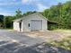 An outbuilding, featuring an exterior door and a roll-up garage door with an attached carport at 505 Sandhill Hickory Level Rd, Carrollton, GA 30116