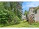 Home's backyard with a charming deck and stairs, surrounded by verdant trees at 1576 King Mill Rd, Mcdonough, GA 30252