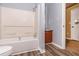 Bathroom features a toilet, tub, and vanity, accented by gray and brown wood-look flooring at 1576 King Mill Rd, Mcdonough, GA 30252