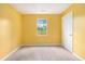 This bedroom features yellow walls, a window and neutral carpet at 1576 King Mill Rd, Mcdonough, GA 30252