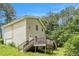 Rear exterior featuring a wood deck, stairs, and siding, set among mature trees at 1576 King Mill Rd, Mcdonough, GA 30252