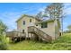 View of the rear exterior with a wooden deck and access stairs, surrounded by greenery at 1576 King Mill Rd, Mcdonough, GA 30252
