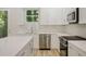 View of the kitchen's appliances and cabinets, complemented by white countertops and a stylish backsplash at 1888 Goddard Se St, Atlanta, GA 30315