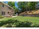 Spacious backyard with well-maintained lawn, stone retaining wall, and a convenient storage shed at 235 Foxley Way, Roswell, GA 30075