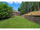 Lush backyard with well-maintained lawn and stone retaining wall at 235 Foxley Way, Roswell, GA 30075