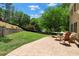 A backyard showing a stone patio and seating area, plus a hammock on a lush green lawn at 235 Foxley Way, Roswell, GA 30075