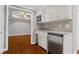 Finished basement features a wet bar with stainless steel appliances and white cabinets at 235 Foxley Way, Roswell, GA 30075