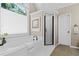 A bathroom with a soaking tub, a window with blinds, and a shower stall at 235 Foxley Way, Roswell, GA 30075