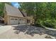 A front view of a three-car garage with a long driveway at 235 Foxley Way, Roswell, GA 30075