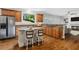 Open kitchen design with stainless steel refrigerator, granite counters, island, and seamless flow to living area at 235 Foxley Way, Roswell, GA 30075