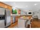 Well-lit kitchen offers stainless steel appliances, granite countertops, island, and open view to the living room at 235 Foxley Way, Roswell, GA 30075
