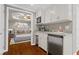 Modern kitchenette with stainless steel appliances, white cabinetry, and view to bedroom space at 235 Foxley Way, Roswell, GA 30075