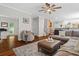Open-concept living room featuring hardwood floors, a ceiling fan, and comfortable seating at 235 Foxley Way, Roswell, GA 30075