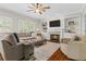 Cozy living room with fireplace, built-in shelves, and large sectional sofa at 235 Foxley Way, Roswell, GA 30075