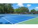 Well-maintained tennis courts with blue and green surfaces surrounded by lush trees at 235 Foxley Way, Roswell, GA 30075
